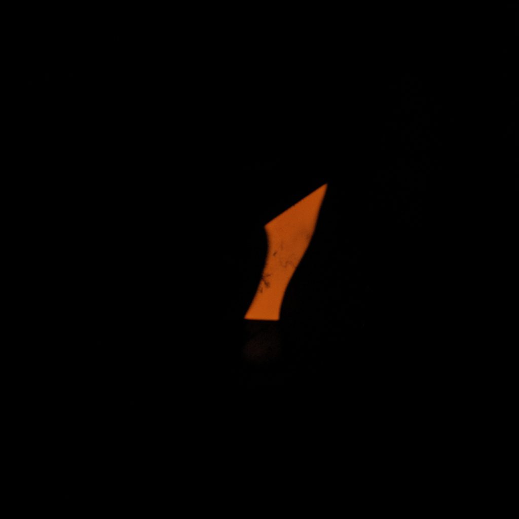 Dark, low-key photograph of an empty question mark shape emerging from deep teal shadow, moody and contemplative